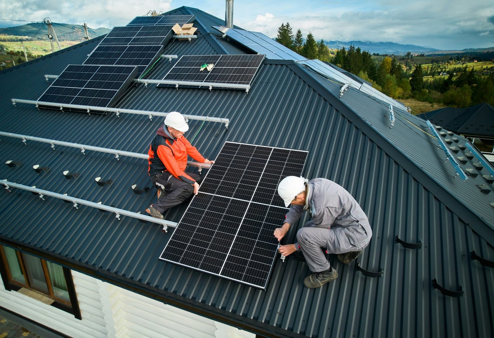 Techniciens installant des panneaux solaires photovoltaïques sur le toit de la maison.